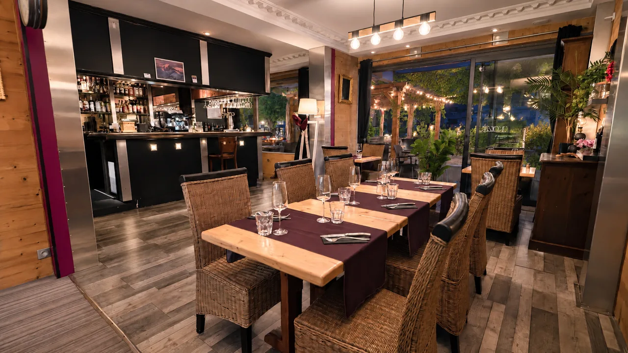 The bar and the laid tables in the evening, in front of the bay window onto the terrace
