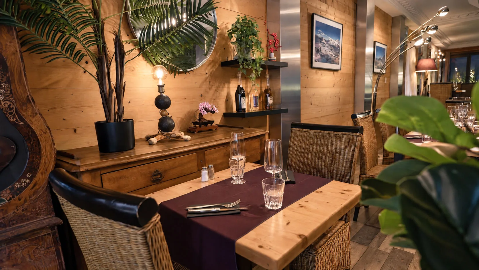 A laid table in front of the sideboard and the round mirror, in the evening